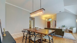 A dining area with a wooden table, black metal chairs, and a hanging light fixture. - 4 Mi to Toyota Stadium! Family Haven w/ Pool Oasis (Frisco)