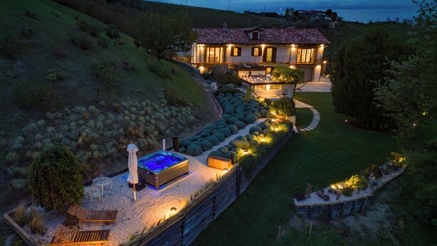 Ein Haus mit Whirlpool, Außenbereich und einem gepflegten Garten.