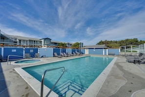 Ein Schwimmbad mit Liegestühlen, ein Poolbereich und ein Gebäude mit blauer Fassade.