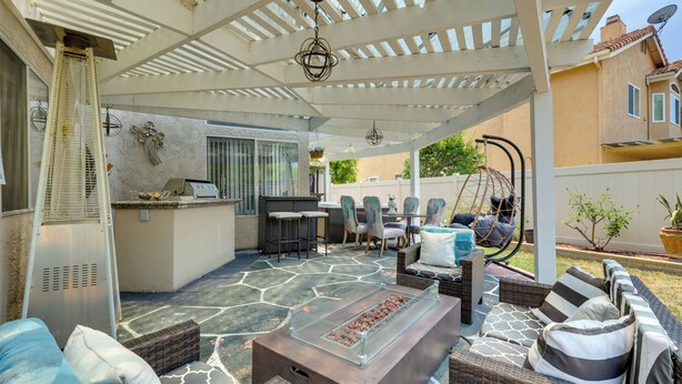 Une terrasse extérieure couverte, aménagée avec des sièges, un barbecue et une table de billard.