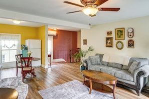 A living room with a sofa, coffee table, and dining area with chairs and a table. - Peaceful Upstate Retreat! Walk to Hudson River (Coxsackie)