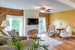 A living room with a fireplace, television, and patterned armchairs. - Peaceful Upstate Retreat! Walk to Hudson River (Coxsackie)