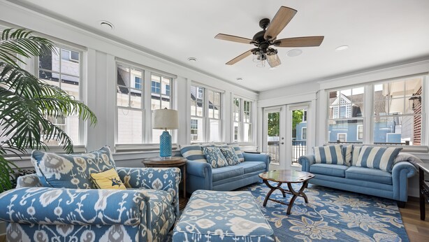 A spacious living room with a large window, a ceiling fan, and a patterned rug. - Downtown Lewes on 2nd Street - #104 - 2nd floor apartment (Lewes)