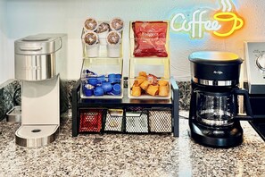A coffee station with a Keurig machine, a Mr. Coffee maker, and various coffee pods and containers.