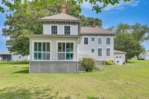 A two-story house with a front porch, a garage, and a well-maintained lawn. - Waterfront Home With Large Yard, Dock & Bay View (Heathsville)
