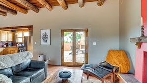Una sala de estar con sofá, sillón, mesa de centro y chimenea.