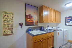 A kitchen with wooden cabinets, a sink, and a poster on the wall.