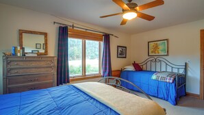 A bedroom with two beds, a dresser, a ceiling fan, a window with curtains, and a wall-mounted picture. - Colorado Riverfront Escape! Fish, Hike & Relax (Pine)