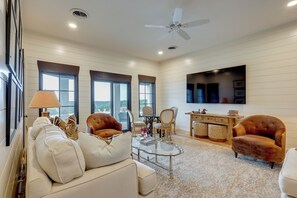 A modern living room with a sofa, chairs, a coffee table, and a TV mounted on the wall. - Stunning Views! Luxurious & Secluded Glen Rose Gem (Glen Rose)