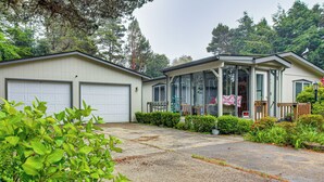 Ein Wohnhaus mit Garage, überdachter Veranda und einem gepflegten Garten.