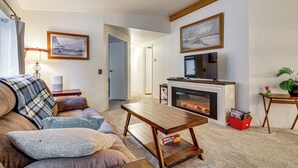 Ein Wohnzimmer mit Kamin, einer Couch, einem Couchtisch und einem Fernseher.