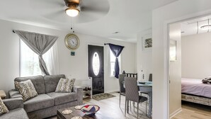 A living room with a sofa, coffee table, and dining area.