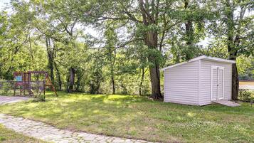 Ein Rasen mit einem Gerätehaus und einer Schaukel.