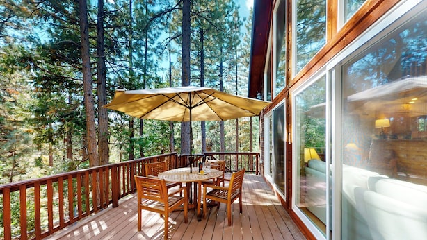 A wooden deck with a table and chairs, surrounded by tall trees. - Projector & Deck! Family Cabin, 4 Mi to Lake Davis (Portola)
