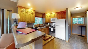 A modern kitchen with wooden cabinets, a built-in oven, and a refrigerator. - Projector & Deck! Family Cabin, 4 Mi to Lake Davis (Portola)