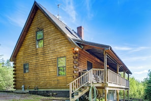 A log cabin with a balcony, a chimney, and a window. - Hike, Explore & Unwind: Rustic Maine Getaway (Machias)