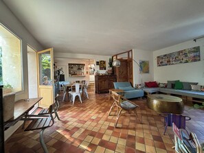 Ein großzügiger Wohnbereich mit Esstisch, Stühlen, einer Couch und einem großen Fenster.