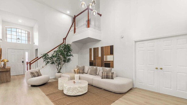 A spacious living room with a large sectional sofa, a round coffee table, and a staircase leading to an upper level. - Disney Villa: Pool, Spa & Mario Bros Game Room (Davenport)