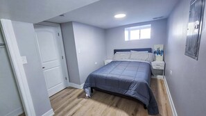 A bedroom with a bed, nightstands, a window, and a door. - Fabulous 3-bedroom townhome with AC in vibrant Chicago (Chicago)
