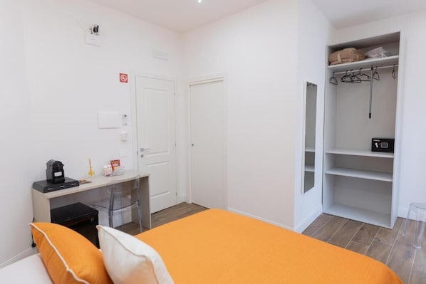 Une chambre à coucher avec un lit, un bureau, une armoire et une chaise.