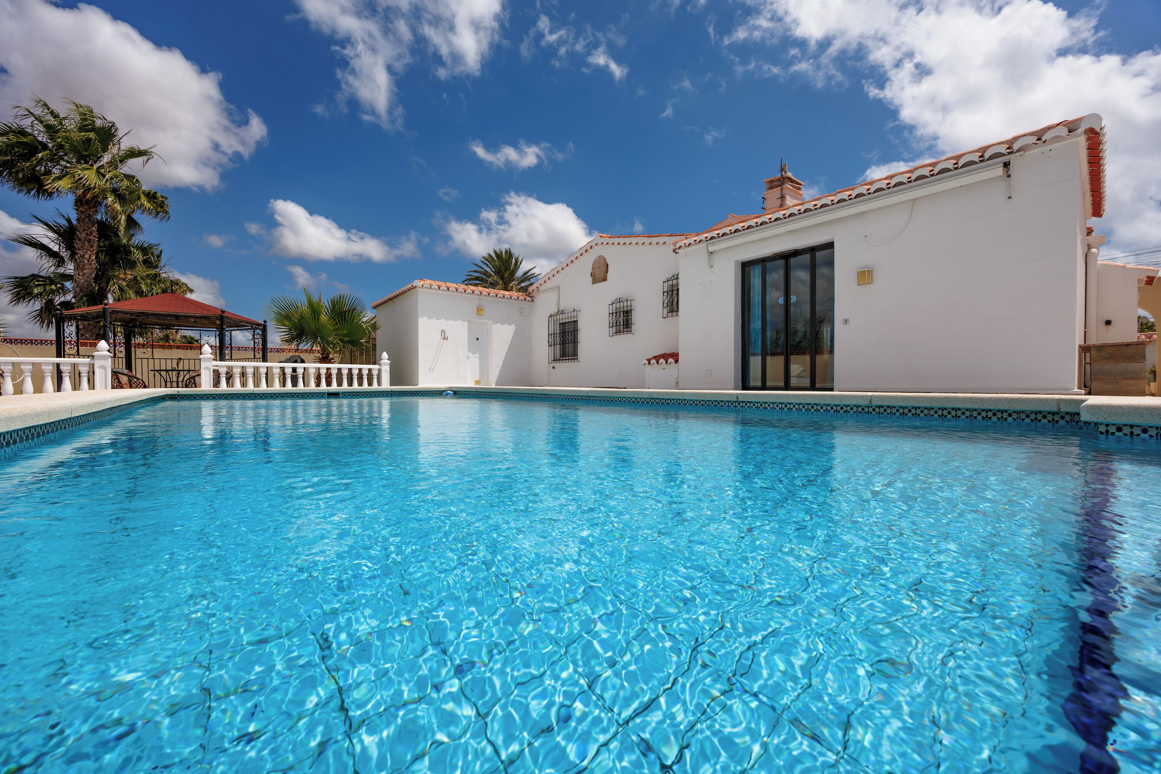 A swimming pool with a white building in the background.