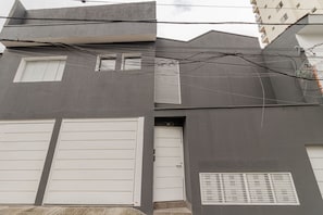 Edifici modern amb porta de garatge, una porta petita i una obertura.