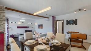 A dining area with a table set for four, a dartboard, and a ping pong table. - Villa Elssa by Villas Guide (Ližnjan)
