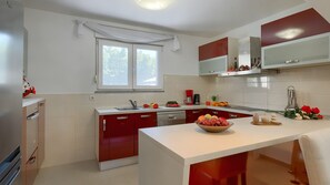 A modern kitchen with a central island, a window, and a built-in oven. - Villa Elssa by Villas Guide (Ližnjan)