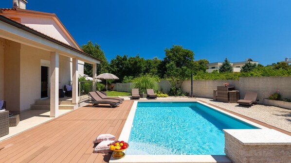A swimming pool with lounge chairs, a covered patio, and a fruit bowl. - Villa Elssa by Villas Guide (Ližnjan)
