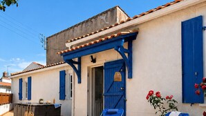 Un patio con dos sillones azules, una mesita y una cesta.