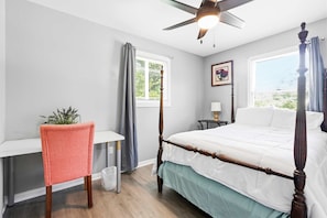 A bedroom with a bed, a desk, a chair, a ceiling fan, and a window. - Lusby 5BD Family Home With Private Beach Access (Lusby)