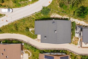 Ein großes, rechteckiges Gebäude mit flachem Dach, umgeben von einer gepflasterten Auffahrt und einer Straße.