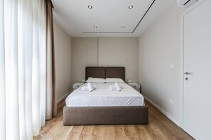Ein modernes Schlafzimmer mit Bett, Nachttischen und einem Kleiderschrank.