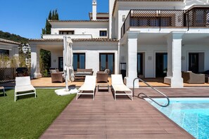 Ein Poolbereich mit Liegestühlen, einem Pool und einem Gebäude mit mehreren Balkonen.