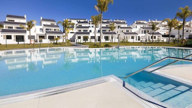 A swimming pool with modern buildings in the background. - ESTEPONA SUNSETS - BRAND-NEW MODERN 3-BEDROOM APARTMENT (Estepona)