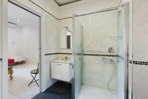 A bathroom with a glass-enclosed shower, a sink, and a mirror. - Queen Studio Apartment with Wi-Fi and Air Conditioning (Salerno)