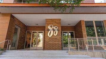 A building entrance with a large number '88' sign, a brick facade, and a set of stairs leading up to the entrance.