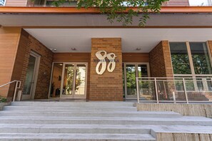 A building entrance with a large number '88' sign, a brick facade, and a set of stairs leading up to the entrance.
