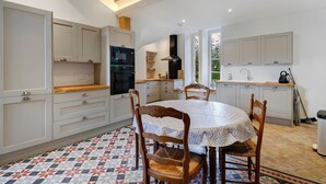 Una cucina con un tavolo da pranzo, sedie e un pavimento decorato.
