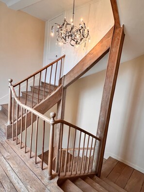 Eine Holztreppe mit einer Chandelüster.