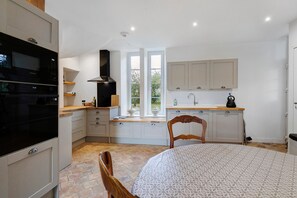 Eine kompakte Küche mit Backofen, Herd und Fenster mit Blick auf einen Garten.
