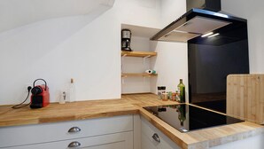 Una cucina con piano cottura a induzione nero, pensili in legno e cappa integrata.