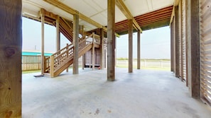 A building under construction with a wooden staircase, concrete floor, and visible wooden beams. - H2O Getaway: 3  BR, 2  BA House in Gilchrist, Sleeps 10 (Gilchrist)