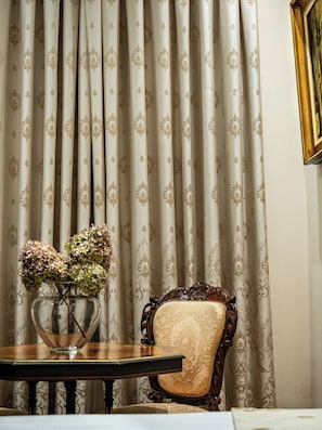 Una habitación con una mesa, una silla y una cortina estampada.