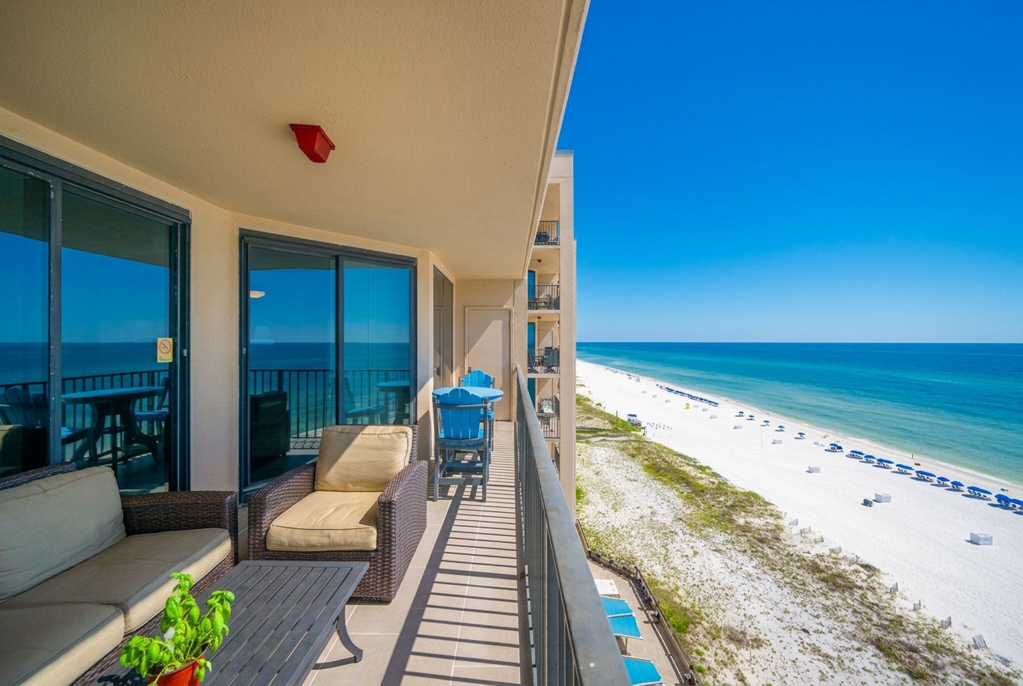 Ein Balkon mit Blick auf den Strand, Sitzgelegenheiten im Freien und ein Pool.