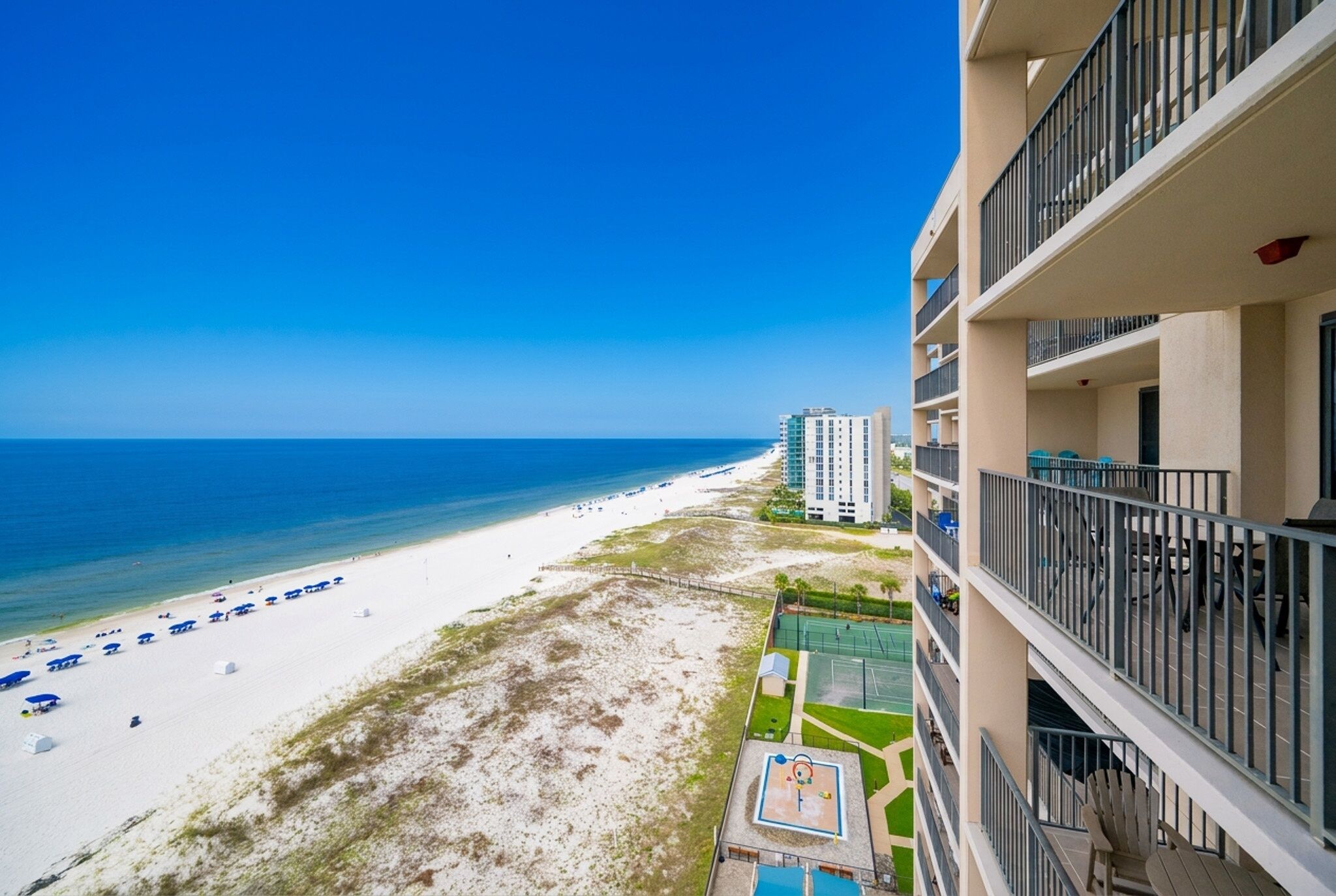 A beachfront hotel with a view of the beach and ocean.