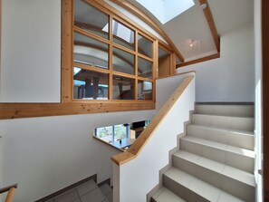 Eine Treppe mit Holzgeländern und einem Oberlicht darüber.