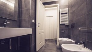 Une salle de bain moderne avec un grand lavabo, un bidet et des toilettes.