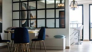 Un intérieur moderne avec une grande fenêtre, un canapé blanc et deux fauteuils bleus.