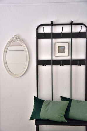 Ein Bett mit Metallgestell, ein an der Wand befestigter Spiegel und ein Bilderrahmen.